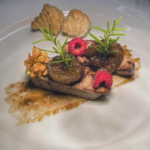a plate of food with meat and flowers on it at Il Castello di Bubbio in Bubbio