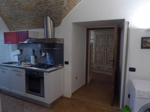 a kitchen with a stove and a door to a hallway at La cantina dei Cappuccini in Spello