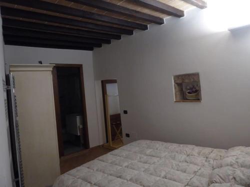 a bedroom with a white bed and a mirror at La cantina dei Cappuccini in Spello