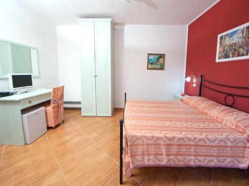 1 dormitorio con 1 cama y escritorio con ordenador en B&B La Formichina, en Peschici