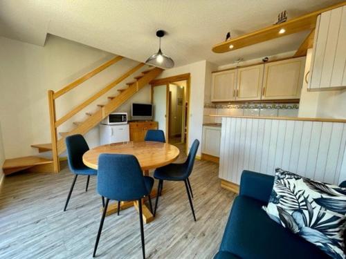 une cuisine et une salle à manger avec une table et des chaises dans l'établissement Duplex confortable à Quiberon - 2 pièces, 4 pers., 38m², balcon, parking, animaux acceptés - FR-1-478-40, à Quiberon