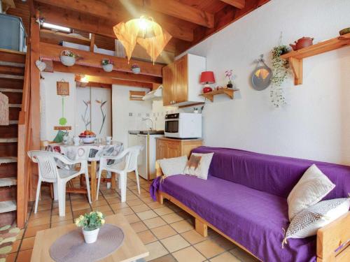 un salon avec un canapé violet et une table dans l'établissement Chalet duplex 4 pers. avec cheminée et parking - Viella - FR-1-402-48, à Viella
