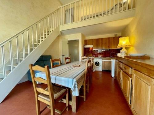 a kitchen with a dining table and a staircase at Appartement Quiberon, 3 pièces, 5 personnes - FR-1-478-75 in Quiberon