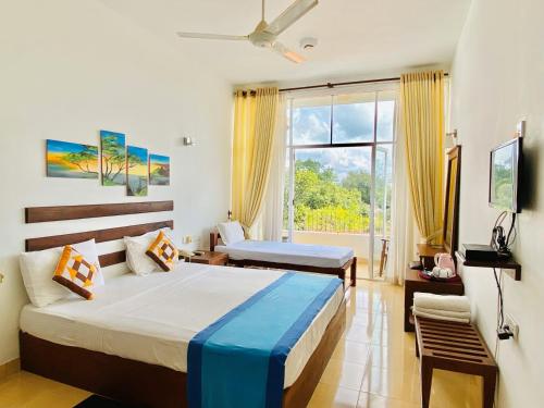 - une chambre avec un lit et une grande fenêtre dans l'établissement Ceylan Lodge, à Anurâdhapura