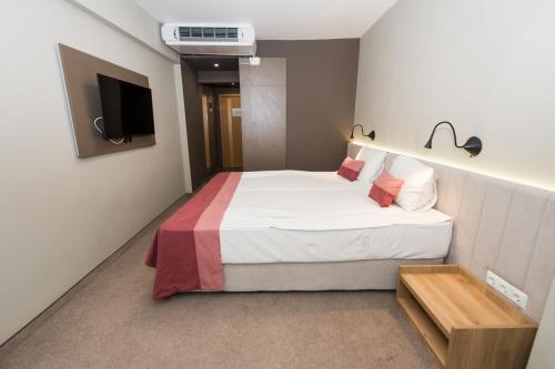 a hotel room with a bed and a tv at Grand Hotel Sunny Beach - All Inclusive in Sunny Beach