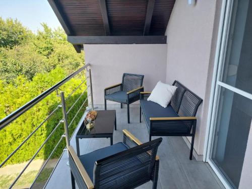 a balcony with two chairs and a table with a table at Ivančica in Aljmaš