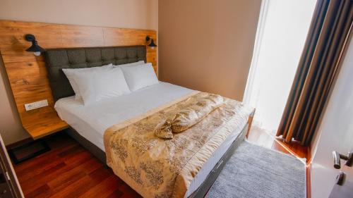 a bedroom with a large bed with a wooden headboard at Gardan Hotel in Beylikduzu