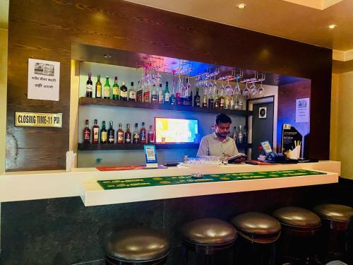 a man standing behind a bar with bottles of alcohol at Hotel Narayana - Best corporate and Family Hotel in the City in Udaipur