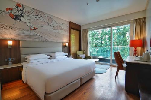 a bedroom with a large bed and a large window at Hyatt Centric Rajpur Road Dehradun in Dehradun