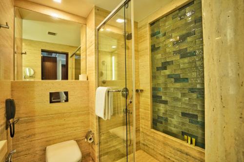 a bathroom with a glass shower with a toilet at Hyatt Centric Rajpur Road Dehradun in Dehradun
