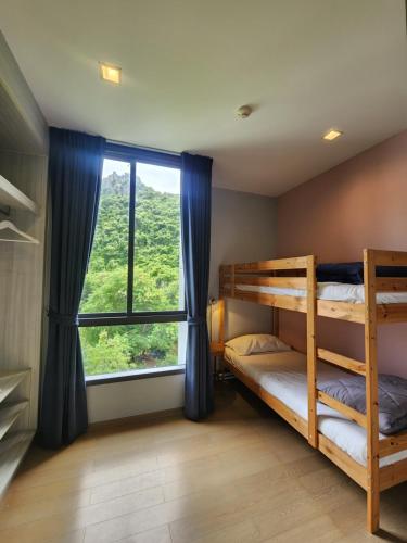 a bedroom with bunk beds and a large window at Mountain View Suite at The Valley Khaoyai in Ban Huai Sok Noi