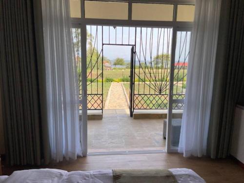 1 dormitorio con puerta que da a un patio con puerta en Villa (9) Del Sol: 1 bedroom, a patio & Lakefront en Kisumu
