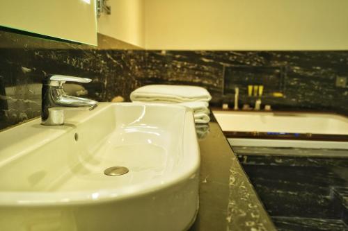 a bathroom with a sink and a bath tub at Hyatt Centric Rajpur Road Dehradun in Dehradun