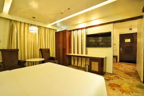 a hotel room with a bed and a table and chairs at Hyatt Centric Rajpur Road Dehradun in Dehradun