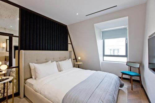 a bedroom with a large white bed and a window at 37GS Residences in London