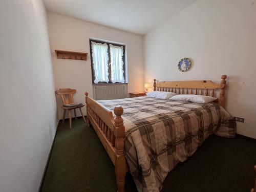 una camera con letto in legno di Bilocale I Fiori 071 a Pinzolo