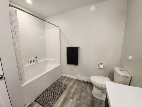 a white bathroom with a toilet and a shower at Comfort First - sleeps 6 in Whitehorse