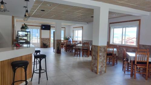 a dining room with tables and chairs and windows at Jumboli in Redondela