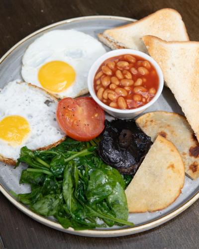 a plate of breakfast food with eggs beans and toast at Kew Gardens Hotel in Kew