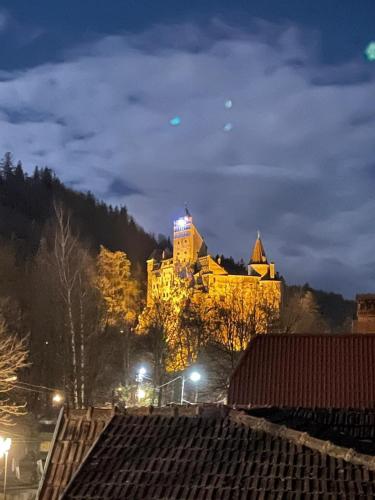 a large yellow building is lit up at night at Zori de zi in Bran