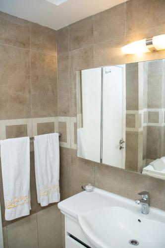 a bathroom with a sink and a mirror at Centaurus Hotel Suites in Islamabad