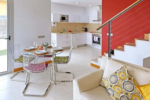 cocina y sala de estar con mesa y sofá en Salobre Vista Golf 1 en Maspalomas