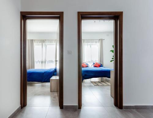un pasillo con 2 espejos y 1 cama en una habitación en Bright Apartment minutes from the Sea, en Il-Gżira