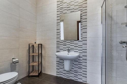 La salle de bains est pourvue d'un lavabo, de toilettes et d'un miroir. dans l'établissement Bright Apartment minutes from the Sea, à Il-Gżira
