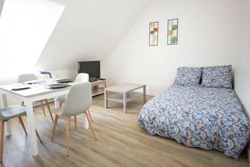 une chambre avec un lit, une table et un bureau dans l'établissement Le Bel-Air AVALLON, à Avallon