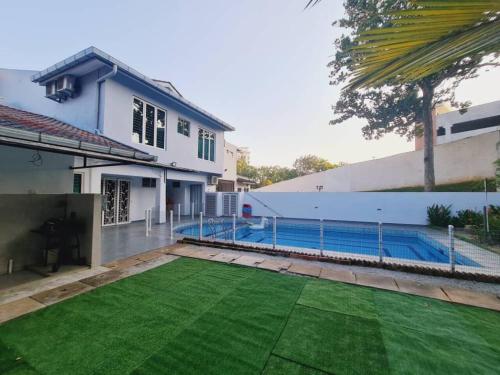 een huis met een zwembad en een tuin bij Pool Villa Melaka up to 18 pax in Melaka