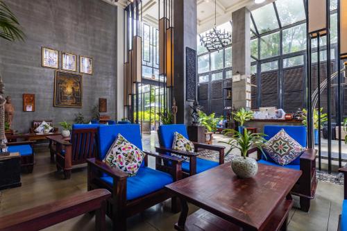 a restaurant with blue chairs and tables and windows at Bayon Modern Residence in Siem Reap