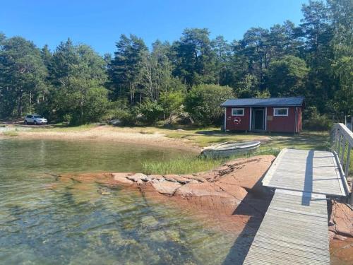 une cabine sur la rive d'un lac avec un quai dans l'établissement Stugan, à Lemland