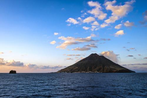 a mountain in the middle of a body of water at Villa Ginestra sulla spiaggia di Stromboli in Stromboli