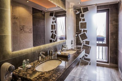 a bathroom with two sinks and a large mirror at 8 1/2 Art Guest House in Plovdiv