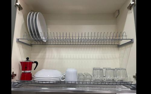- une étagère de cuisine avec de la vaisselle et des verres dans l'établissement La perla di Napoli e della Costiera, à San Vitaliano 
