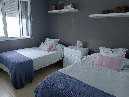 1 dormitorio con 2 camas, vestidor y 2 ventanas en Agua, en Aracena