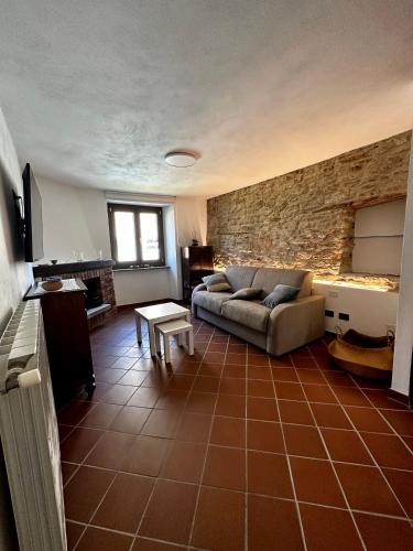 a living room with a couch and a stone wall at Ca d’Censo in Marsaglia
