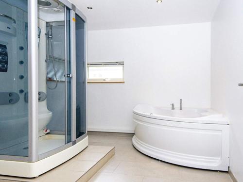 a bathroom with a toilet and a glass shower at 14 person holiday home in Grenaa in Grenå