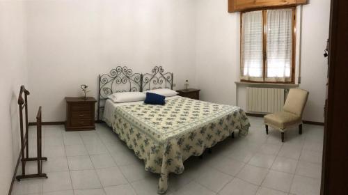 ein Schlafzimmer mit einem Bett und einem Stuhl darin in der Unterkunft Casa Dani con piscina privata in Monticiano