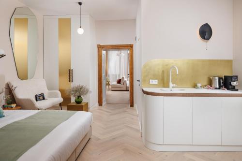 um quarto com uma cama, um lavatório e uma cozinha em Aries' Collection Luxury Suites em Braşov