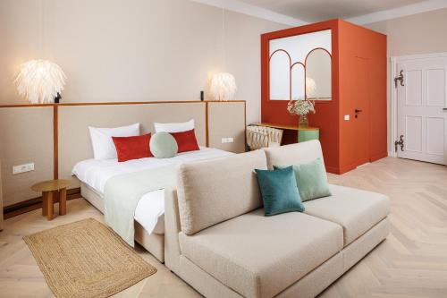 a bedroom with a large bed and a couch at Aries' Collection Luxury Suites in Braşov