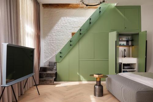 a bedroom with a green wall with a staircase at Aries' Collection Luxury Suites in Braşov