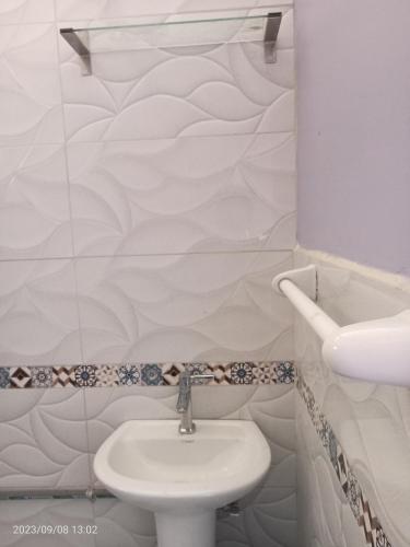 een witte badkamer met een wastafel en een toilet bij La casa de Yllari in Cuzco
