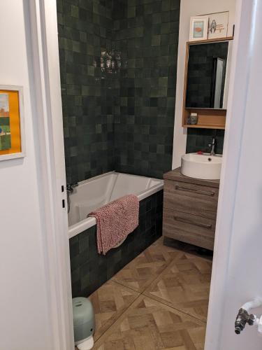 une salle de bain avec une baignoire et un lavabo dans l'établissement Appartement avec balcon proche de Montmartre, à Paris