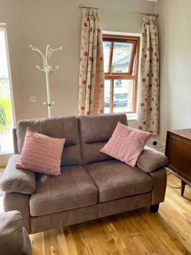 a brown couch with two pillows on it in a living room at The Stone Cottage in Castlebar