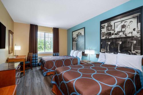 ein Hotelzimmer mit 2 Betten und einem Tisch in der Unterkunft Super 8 by Wyndham Salisbury in Salisbury