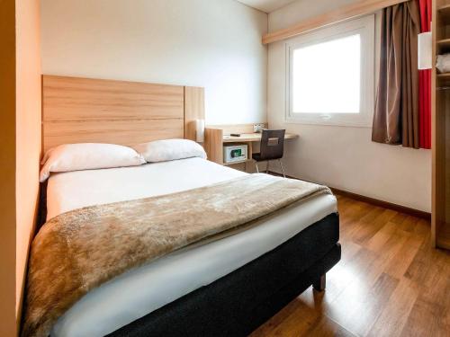 - une chambre avec un grand lit et une fenêtre dans l'établissement ibis Concepcion, à Concepción