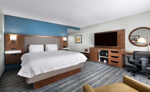 een hotelkamer met een bed en een flatscreen-tv bij Hampton Inn Belmont at Montcross in Belmont