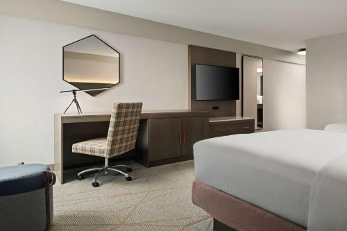 a bedroom with a bed and a desk and a television at DoubleTree by Hilton Pittsburgh Airport in Moon Township