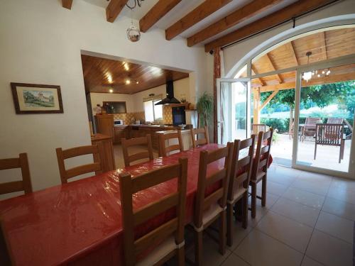 une salle à manger avec une table et des chaises et une cuisine dans l'établissement Votre gîte en Périgord : La Grangette., à Sauveterre-la-Lémance